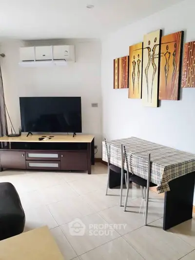 Modern living room with air conditioning, TV, and stylish decor in a cozy apartment.