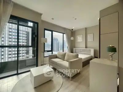 Modern studio apartment with city view, featuring a cozy living area and large windows.