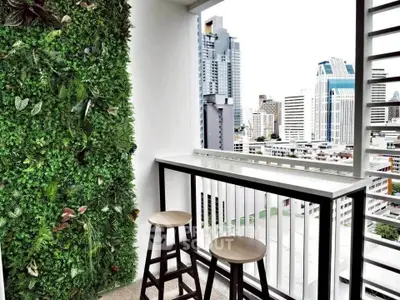 Modern balcony with lush vertical garden and city skyline view, perfect for urban living.