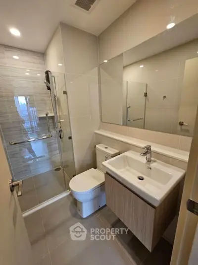 Modern bathroom with glass shower and sleek fixtures in contemporary apartment