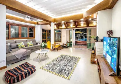 Spacious living room with modern decor and pool view, perfect for relaxation and entertainment.