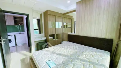 Modern bedroom with built-in wardrobe and view into compact laundry area