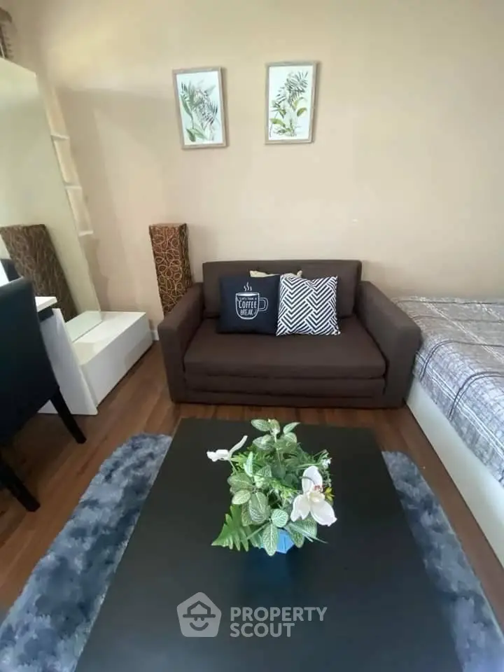 Cozy living room with brown sofa, stylish decor, and wooden flooring.
