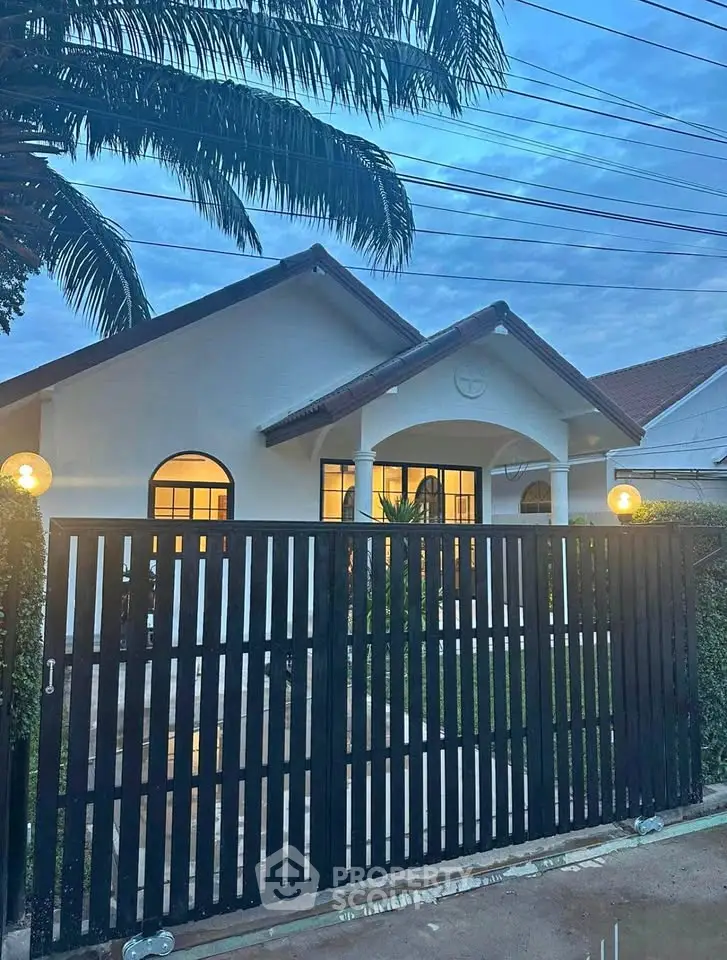 Charming single-story home with modern exterior and gated entrance at dusk.