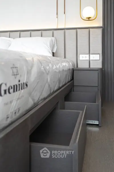 Modern bedroom with built-in storage drawers under bed and stylish lighting.