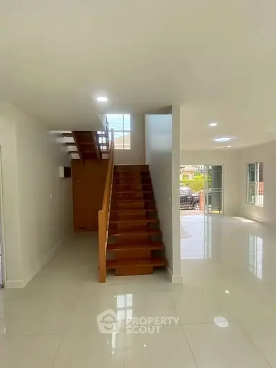Spacious modern living area with elegant staircase and natural light