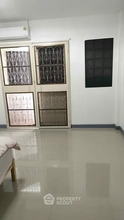 Spacious room with polished floors and secure window grills, ideal for modern living.