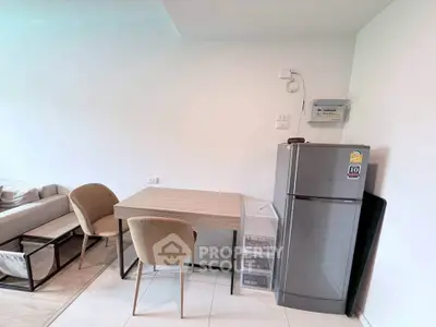 Modern living space with dining area and sleek refrigerator, perfect for urban living.