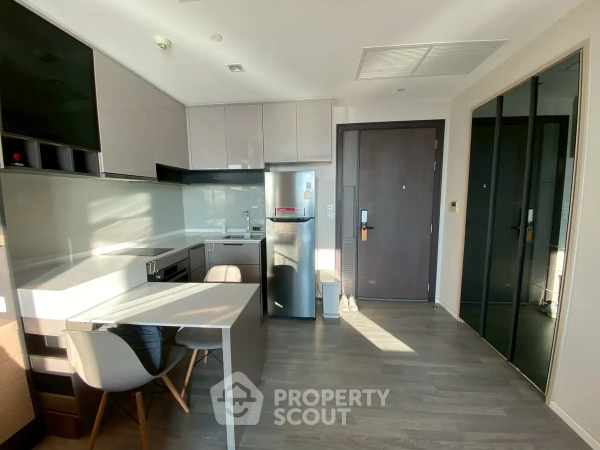 Modern kitchen with sleek cabinetry and stainless steel appliances in a bright apartment.