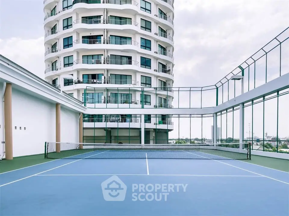 Luxurious high-rise building with modern tennis court offering stunning city views.