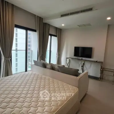 Modern bedroom with large windows and stylish decor in a high-rise apartment.