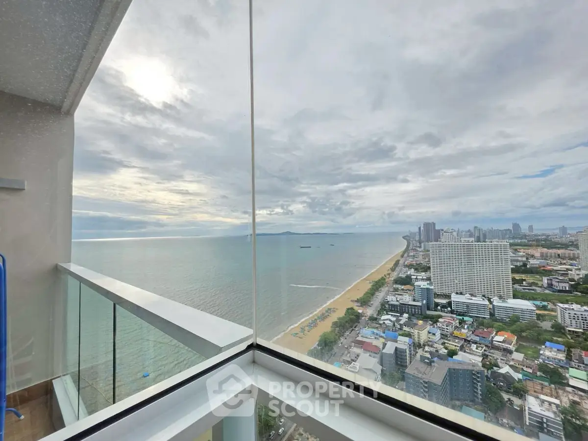 Stunning panoramic ocean view from high-rise balcony overlooking cityscape and coastline.