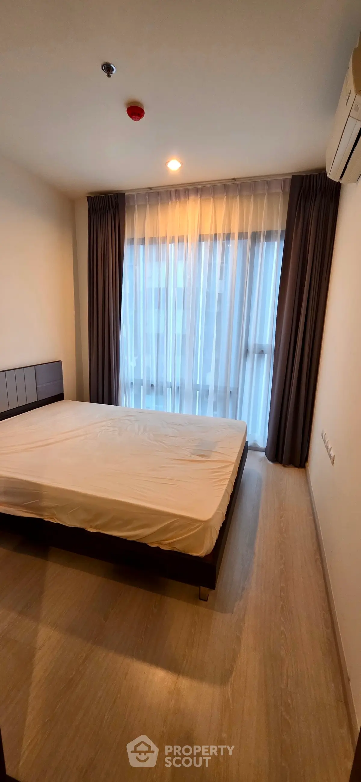 Modern bedroom with large window and minimalist design in a stylish apartment.
