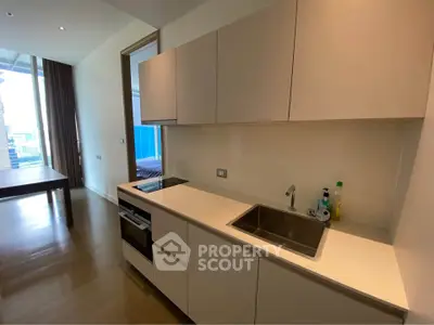 Modern kitchen with sleek cabinetry and integrated appliances in open layout apartment