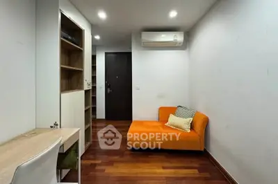 Modern study room with orange chaise lounge and wooden flooring