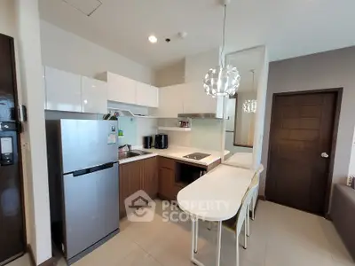 Modern kitchen with sleek appliances and stylish lighting in a contemporary apartment.