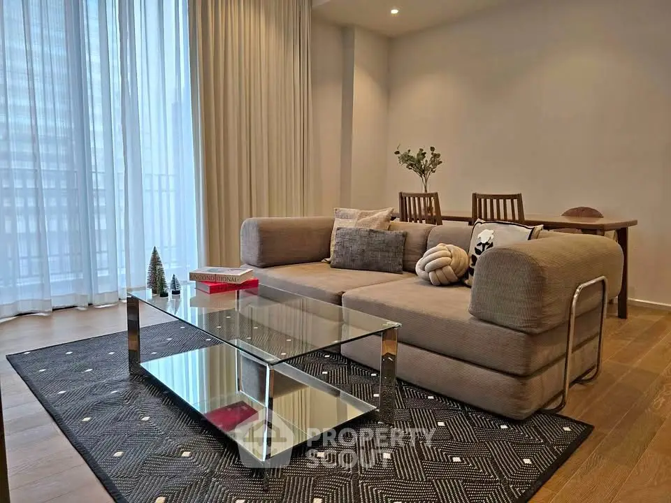 Modern living room with stylish sofa, glass coffee table, and elegant decor in a bright apartment.