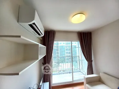 Modern living room with balcony view, featuring sleek air conditioning and cozy sofa.