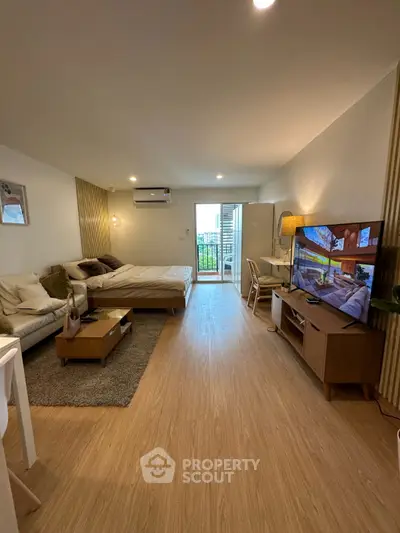 Modern studio apartment with open layout, cozy living area, and balcony access.