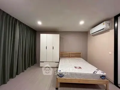 Spacious bedroom with modern furnishings and air conditioning, ideal for comfort and relaxation.