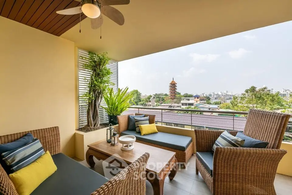 Charming balcony with wicker furniture and city view, perfect for relaxation.