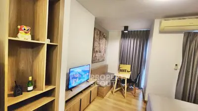 Modern living room with wooden furniture and air conditioning, featuring a cozy TV area and stylish decor.