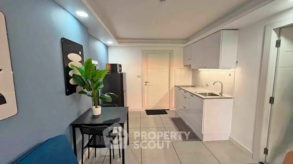 Modern kitchen with sleek cabinetry and dining area in a stylish apartment