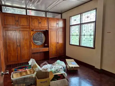Spacious bedroom with wooden built-in wardrobe and large window