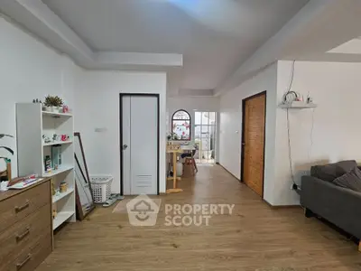 Spacious living room with wooden flooring and modern decor in a cozy apartment.