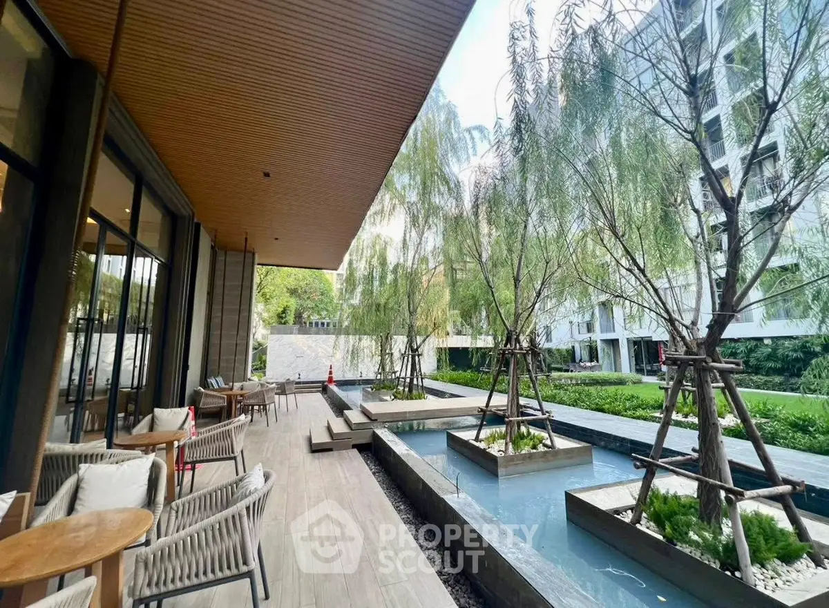 Luxurious outdoor garden area with modern seating and water features in a high-end residential complex.