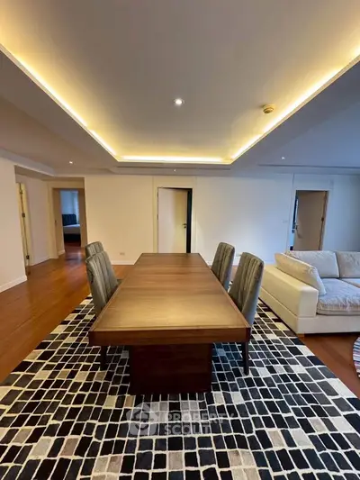Spacious dining area with elegant wooden table and modern lighting in luxury apartment.