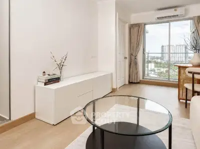 Modern living room with glass coffee table and balcony view in a stylish apartment.