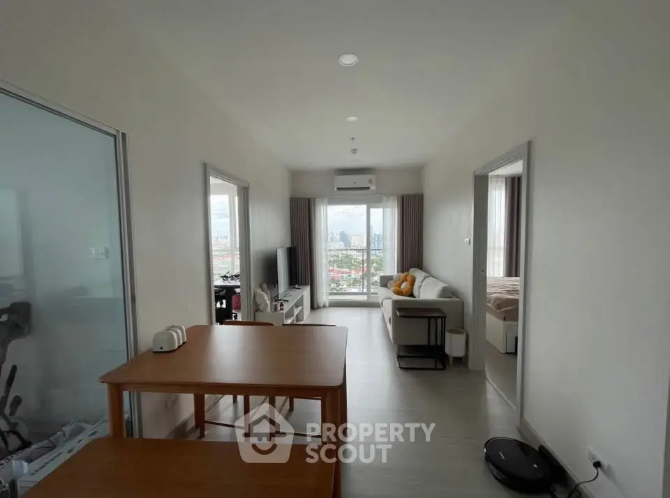 Modern apartment living room with city view, featuring sleek furniture and natural light.