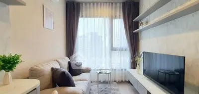 Cozy living room with modern decor and large windows offering city views.