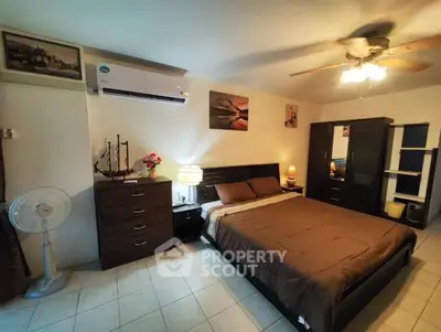 Cozy bedroom with modern furniture and ceiling fan, featuring a comfortable bed and ample storage space.