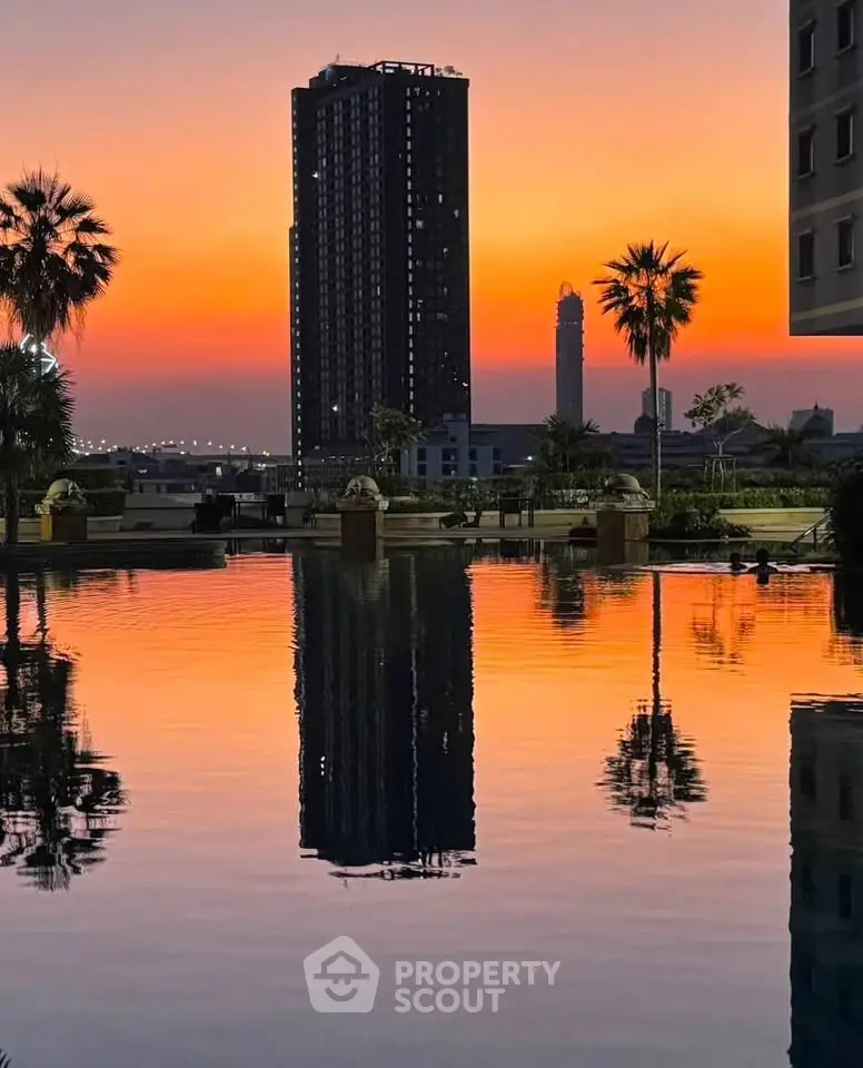 Stunning sunset view over a serene pool with city skyline backdrop, perfect for luxury urban living.