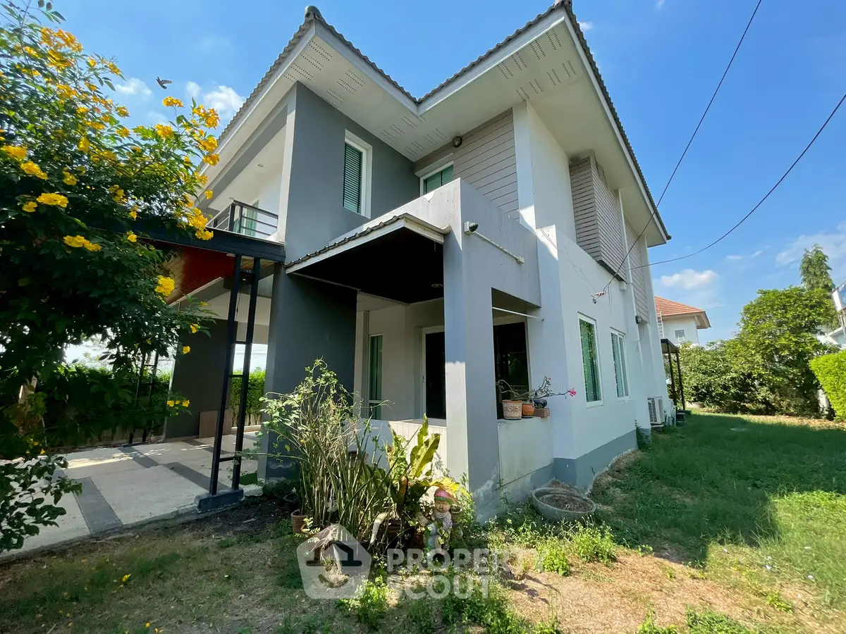 Charming two-story house with lush garden and modern exterior design.