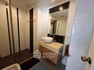 Modern bathroom with stylish sink and large mirror in contemporary apartment.