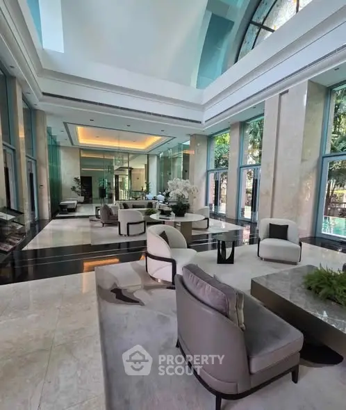 Luxurious high-ceiling lobby with elegant seating and floor-to-ceiling windows.