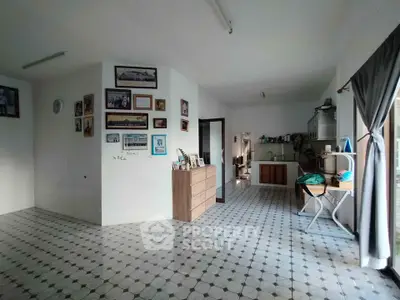 Spacious open-plan living area with tiled flooring and modern kitchen.