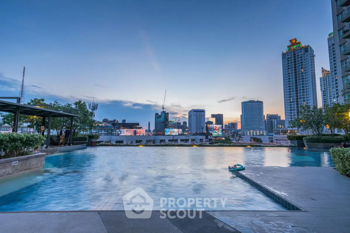 Luxurious rooftop pool with stunning city skyline view at sunset.