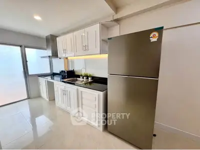 Modern kitchen with sleek cabinets and stainless steel fridge in bright apartment