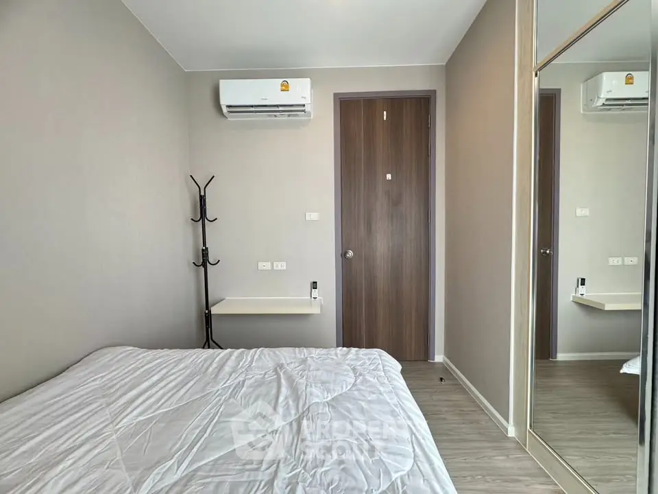 Modern bedroom with air conditioning and mirrored closet in stylish apartment.