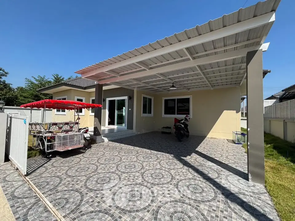 Charming single-story home with spacious covered carport and tiled driveway, perfect for modern living.