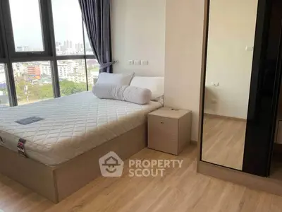 Modern bedroom with large window and city view, featuring a comfortable bed and sleek wooden flooring.