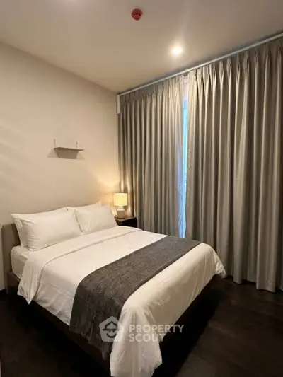 Cozy bedroom with elegant curtains and soft lighting, perfect for relaxation.