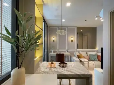 Modern living room with stylish decor and open layout, featuring a cozy seating area and elegant lighting.