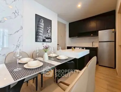 Modern kitchen with sleek black cabinets, marble accent wall, and elegant dining setup.
