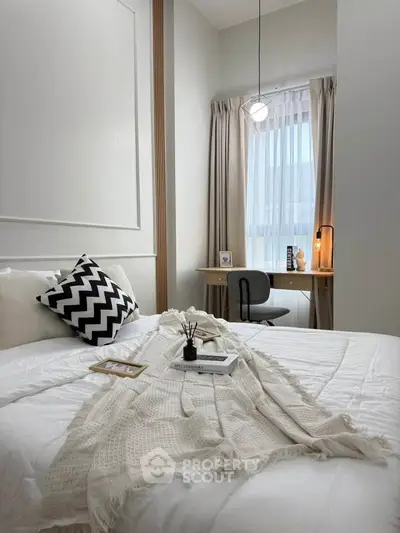 Cozy bedroom with modern decor and natural light, featuring a stylish workspace by the window.