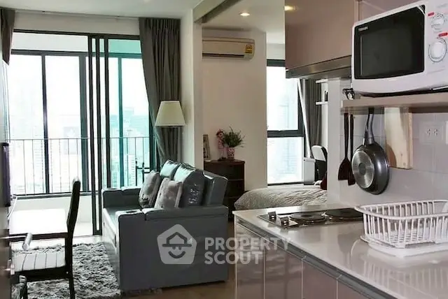 Modern open-plan living room with kitchen and balcony view in a stylish apartment.